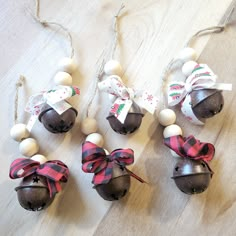 four ornaments with bows on them sitting on a wooden floor next to twine strings