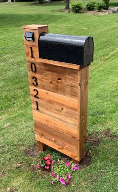 a wooden mailbox sitting in the grass