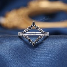 a diamond ring sitting on top of a blue cloth