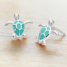 Dive into artistic elegance with our Enamel Sea Turtle Studs—a creative masterpiece crafted to transport wearers to blissful, sun-filled days by the ocean. These earrings aren't just accessories; they are wearable art designed to embody the tranquil beauty of sea turtles gliding through the azure waves. Elevate your style effortlessly by pairing these unique studs with our exclusive collection of nautically-inspired pieces, creating a harmonious ensemble that mirrors the allure of maritime life. Ocean-inspired Jewelry For Summer, Summer Ocean-inspired Jewelry In Ocean Color, Ocean-inspired Green Jewelry For Vacation, Green Ocean-inspired Jewelry For Vacation, Handmade Ocean Color Jewelry For Summer, Adjustable Ocean Color Summer Jewelry, Handmade Ocean Color Summer Jewelry, Summer Ocean Color Adjustable Jewelry, Ocean-inspired Earrings For Summer Gift