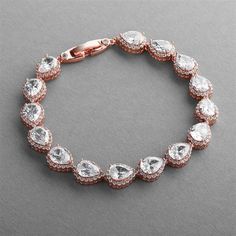 Rose Gold CZ Wedding Bracelet Exquisite quality rose gold cz bridal statement bracelet. This stunning bridal bracelet will add a glamorous touch to your wedding day look. It features glistening pear shaped CZ crystals framed with smaller cz gems. This bracelet will coordinate well with our other rose gold Cubic Zirconia jewelry making it a beautiful choice for the bride, mother of the bride or bridesmaids. This stunning bracelet is plated in Genuine Rose Gold and features AAAAA Quality CZ stones Rose Gold Wedding Accessories, Gold Bracelet Wedding, Shaped Crystals, Mens Gold Wedding Band, Cubic Zirconia Bracelet, Rose Gold Crystal, Bling Wedding, Cubic Zirconia Jewelry, Rhinestone Bridal