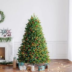 a decorated christmas tree in the corner of a living room with presents on the floor