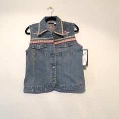 Bill Blass. Vintage Light Wash, Button Front Denim Vest With Floral Embroidery, Gem Embellishments And Floral Patchwork Trim On Bottom. There Are Few Gems Missing. See Pics New With Tag. Dead Stock Bill Blass Size Medium 100% Cotton Approximately Measures 19 Pit To Pit 22.5 Long Casual Embroidered Denim Vest For Spring, Casual Embroidered Denim Vest For Summer, Fitted Embroidered Denim Vest Casual, Casual Embroidered Fitted Denim Vest, Casual Denim Vest With Floral Embroidery For Spring, Casual Floral Embroidered Denim Vest For Spring, Y2k Cotton Denim Vest For Spring, Y2k Style Cotton Denim Vest For Spring, Blue Embroidered Denim Vest