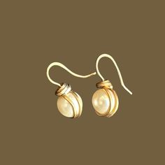 Elevate any look with our Hand Wrapped Swarovski Pearl Earrings. Perfect for brides and bridesmaids, these drop earrings blend simple gold with timeless elegance. Ideal for special occasions or everyday wear, they make a thoughtful gift. Capture the essence of sophistication with these stunning earrings. Elegant Wire Wrapped Earrings For Formal Occasions, Gold Wire Wrapped Earrings For Formal Occasions, Formal Gold Wire Wrapped Earrings, Elegant Wire Wrapped Wrap Earrings As Gift, Elegant Handmade White Wrap Earrings, Elegant Wedding Wrap Earrings With Ear Wire, Elegant Adjustable Wire Wrapped Earrings, Formal Wire Wrapped Drop Earrings, Adjustable Wrap Earrings For Wedding