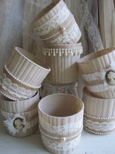 there are many vases stacked on top of each other with lace around the edges