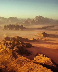 an aerial view of the desert with rocks and mountains in the distance, taken from above