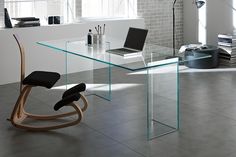 a glass desk with a laptop on it