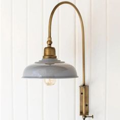 a light that is on the wall next to a white wall and some wood planks