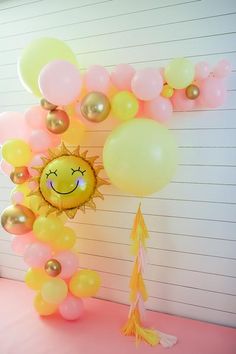 the balloon arch is decorated with yellow and pink balloons