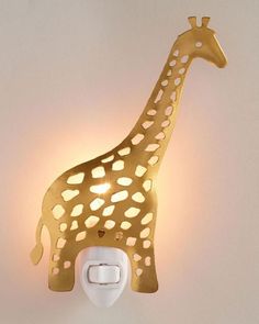 a gold giraffe night light on a white wall