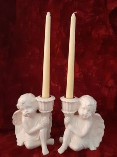 two white candles sitting next to each other