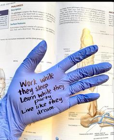 an open book with words written on it and hands in blue gloves holding the book