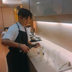 a man in an apron pours wine into glasses