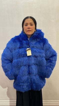 The electric blue faux fur coat is soft, fluffy and luxurious this long sleeve faux fur coat is cozy with a hood and has a voluminous silhouette. Fully lined in black and silver-tone zip-up closure at front. Hooded Fluffy Faux Fur Coat, Hooded Faux Fur Coat With Fluffy Detail, Fluffy Hooded Faux Fur Coat, Blue Faux Fur Winter Coat, Blue Faux Fur Coat For Winter, Winter Blue Faux Fur Coat, Fluffy Blue Outerwear For Winter, Blue Fluffy Winter Outerwear, Long Sleeve Faux Fur Coat