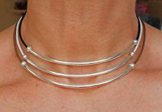 "One sleek silver tube bead on leather makes a gorgeous festival choker necklace! Minimalist, casual, boho chic accessory in your choice of leather colors. This listing is for one single strand choker necklace. This is a beautiful, go-with-anything gift for anniversary, Mother's Day, birthday, graduation, Christmas or any occasion. Lightweight and comfortable, each necklace consists of a single 2mm cord of genuine leather combined with a simply chic silver plated tube bead and round ball crimps. Silver Minimalist Choker For Festivals, Minimalist Silver Choker For Festivals, Boho Chic Accessories, Tube Necklace, Gift For Anniversary, Leather Choker Necklace, Muslin Bags, Neck Choker, Simply Chic