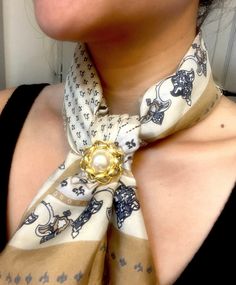 a woman wearing a scarf with an animal print on it and a gold ring around the neck