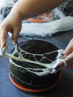 someone is decorating a cake with white icing