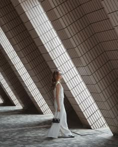 a woman in a white dress is walking down the street