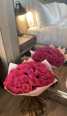 two bouquets of pink roses are sitting on the floor in front of a mirror