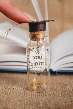 a person is holding a tiny bottle with gold flakes in it and the words you did it written on it