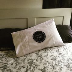 there is a pillow on the bed that says happy birthday in black and white lettering