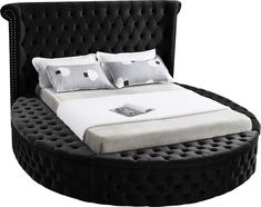 a black and white bed with four pillows on it's headboard, in front of a white background