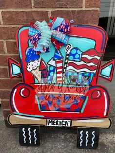 a red car with an american flag on the hood and some decorations attached to it