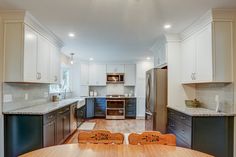 Kitchen remodel with white upper cabinets, a grey backsplash, light granite countertops, new vinyl plank flooring, and farm sink under the bay window