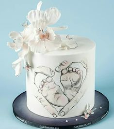 a white cake decorated with flowers and two hands