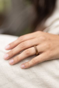 a woman's hand with a wedding ring on her left wrist, resting on the pillow