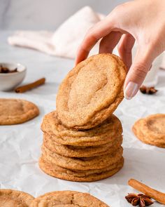 a stack of cookies on top of each other next to cinnamon sticks and anisette