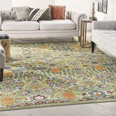 a living room filled with furniture and a rug on top of a wooden floor next to a white couch