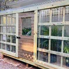 a building made out of wood and glass with plants in the window panes on each side