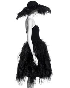 a woman in a black dress and ostrich feathers