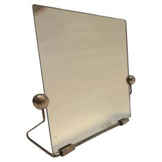 a mirror with two balls attached to the back of it's frame, against a white background