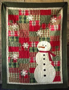 a quilted snowman is hanging on the wall