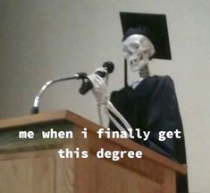 a skeleton wearing a graduation cap and gown stands at a podium with a microphone in front of him