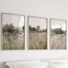 two paintings hanging on the wall above a bed in a room with white sheets and pillows