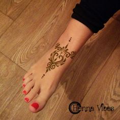 a woman's foot with a henna tattoo on it