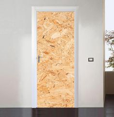 an open door in a white room with wood paneling on the wall and floor