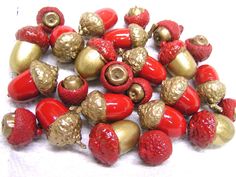 red and gold beads with golden accents on white table top next to strawberries or raspberries