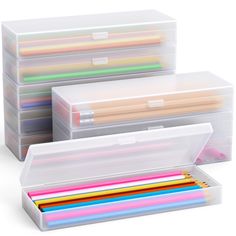 three clear storage boxes with colored pencils in them