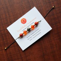 an orange and black beaded bracelet on a card