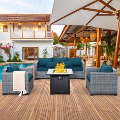 an outdoor living area with blue couches and fire pit