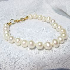 Gorgeous cultured real pearls hand knotted with silk thread, a classic look. These lustrous oval pearls are white and almost perfect.  Since pearls are a natural material, there may be slight variations. Pearls are a great Christmas gift for your wife, especially for your 3rd Anniversry. Pearls are one of June's birthstones, a great birthday gift.  Also pearls are classic looks for weddings and job interviews.  Perfect gifts for brides, bridesmaids and new college graduates on the job market.  Choose  a gold colored or silver colored lobster claw clasp.   7 inches is the average bracelet length.  Choose your custom fit from the drop down menu/message me if you don't see your preferred bracelet length in the drop down menu. I recommend 1 inch longer than your actual wrist size.  Measure you Real Pearl Bracelet, 3rd Wedding Anniversary, Best Friend Birthday Gift, Friend Birthday Gift, Christmas Gifts For Wife, Wedding Jewelry Bracelets, Gift For Brother, Best Friend Birthday, June Birthstone