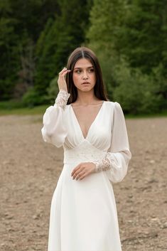 a woman in a white dress is standing on the ground and talking on her cell phone