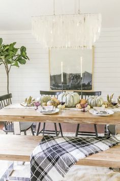 a dining room table is set with plates and place settings for fall dinner party guests