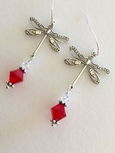 "Beautiful antique silver filigree dragonfly earrings featuring lovely large 8mm Siam red Swarovski Crystal and 4mm clear Swarovski Crystal AB. Silver dragonfly charms are 24 x 24mm and hang from Sterling silver ear wires. Total length is 2\". Lightweight and beautiful red crystal earrings! Available on Sterling silver ear wires or silver plated wires." Elegant Dragonfly Jewelry With Ear Wire, Elegant Dragonfly Earrings With Ear Wire, Elegant Dragonfly Jewelry For Jewelry Making, Elegant Hypoallergenic Dragonfly Earrings, Trendy Jewelry Ideas, Paris Charm Bracelet, Dragonfly Charm, Dragonfly Earrings, Button Jewelry