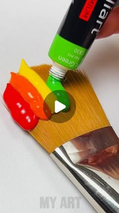 a person is painting the side of a paintbrush with different colored paints on it