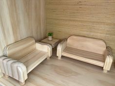 two wooden chairs and a table in a room with wood paneling on the walls